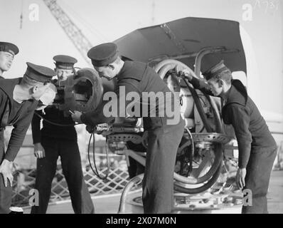 ARRIVAL OF THE FIRST FLOTILLA OF AMERICAN DESTROYERS FOR ROYAL NAVY. 28 SEPTEMBER 1940, ROYAL DOCKYARD, DEVONPORT. THE FLOTILLA, HANDED OVER BY THE US GOVERNMENT UNDER THE AGREEMENT, WERE MANNED ENTIRELY BY BRITISH CREWS. - Members of the crew examining one of the American guns Stock Photo