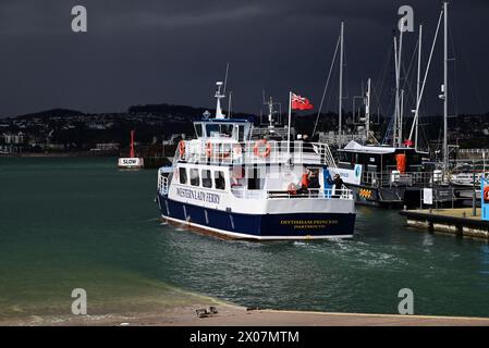 Sunshine and dark clouds over boats in Torquay harbour, as rain approaches and Western Lady Ferry Dittisham Princess departs for Brixham. Stock Photo