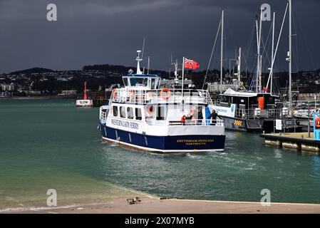 Sunshine and dark clouds over boats in Torquay harbour, as rain approaches and Western Lady Ferry Dittisham Princess departs for Brixham. Stock Photo