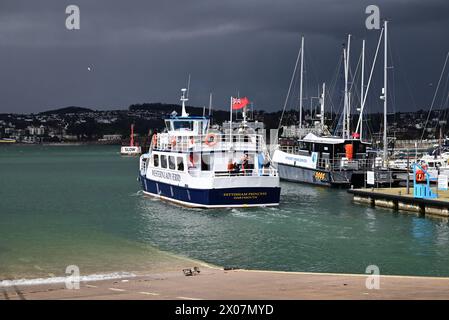 Sunshine and dark clouds over boats in Torquay harbour, as rain approaches and Western Lady Ferry Dittisham Princess departs for Brixham. Stock Photo