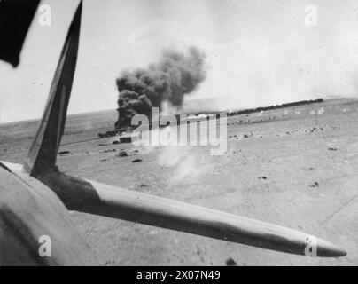ROYAL AIR FORCE OPERATIONS IN THE MIDDLE EAST AND NORTH AFRICA, 1939-1943. - An enemy supply train carrying guns and ammunition is set on fire near Bir Abu Mischeifa, during an attack by four Bristol Beaufighters of No. 252 Squadron RAF and three Bristol Bisleys of No. 15 Squadron SAAF. The photograph was taken from the observer's position in one of the Beaufighters, as it flew away from the target  Royal Air Force, Maintenance Unit, 252, South African Air Force, Sqdn, 15 Stock Photo