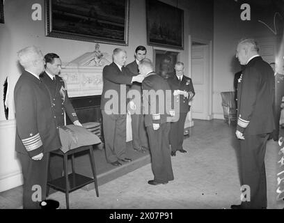 AMERICAN ADMIRALS PRESENTED WITH THE INSIGNIA OF THE MOST HONOURABLE ORDER OF THE BATH. 1 FEBRUARY 1944, THE FISH ROOM, ADMIRALTY HOUSE. THE FIRST LORD OF THE ADMIRALTY, MR A V ALEXANDER, PRESENTED REAR ADMIRAL ALAN G KIRK, USN, AND REAR ADMIRAL JOHN L HALL, USN, WITH THE INSIGNIA OF THE ORDER OF THE BATH. - The First Lord of the Admiralty, the Right Hon A V Alexander presenting Rear Admiral Alan G Kirk, USN with the Insignia of the Order of the Bath. On the Dias with the First Lord is the US Ambassador, the Hon J G Winant, and on the right is the First Sea Lord, Admiral of the Fleet, Admiral Stock Photo