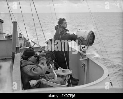 LIBERATION OF EUROPE: WITH AN INVASION COAST CONVOY ESCORT. 11 TO 13 JUNE ON BOARD THE FRIGATE HMS HOLMES GUARDING THE ALLIED SUPPLY LINES TO AND FROM THE NORMANDY BEACHHEAD. - Signalman, Yeoman of Signals, and look-out as one of the escorts was being flashed Stock Photo
