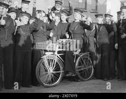 ARRIVAL OF THE FIRST FLOTILLA OF AMERICAN DESTROYERS FOR ROYAL NAVY. 28 SEPTEMBER 1940, ROYAL DOCKYARD, DEVONPORT. THE FLOTILLA, HANDED OVER BY THE US GOVERNMENT UNDER THE AGREEMENT, WERE MANNED ENTIRELY BY BRITISH CREWS. - Members of the crew of the Flotilla leader (HMS CASTLETON) with an American bicycle they bought in America Stock Photo