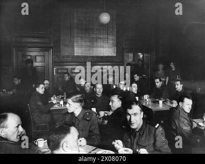 THE ALLIED ARMIES IN BRITAIN, 1940-1945 - Allied troops taking a lunch in the snack bar of the United Nations Forces Club at 11 St. James Square in London. The soldier in the middle foreground is Lance Sergeant of the 1st Polish Armoured Division  Polish Army, Polish Armed Forces in the West, 1st Armoured Division, British Army Stock Photo