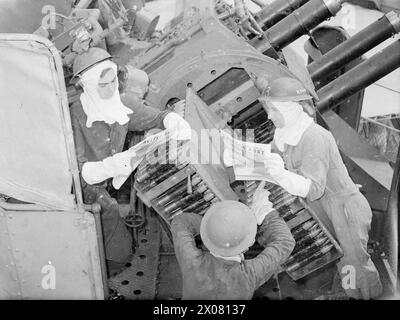 BRITISH PACIFIC FLEET'S NEWSPAPER. AUGUST 1945, SYDNEY, AUSTRALIA. PRODUCTION AND DISTRIBUTION OF THE BRITISH PACIFIC FLEET'S OWN NEWSPAPER, 'PACIFIC POST', BY THE NAVY, FOR THE NAVY. - Reading Pacific Post in a British Pacific Fleet destroyer during a lull in 'action stations': Able Seaman F R Bowmer of Romford, Essex; Able Seaman E Keating of Marlowe, Bucks; and Able Seaman H Davies of Liverpool Stock Photo