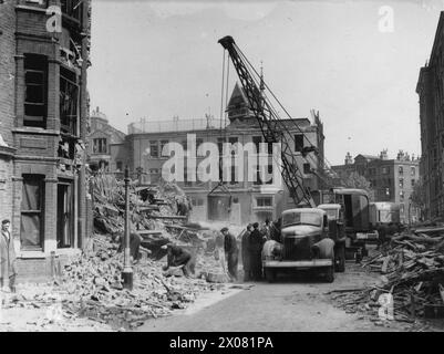 On 7 June 1942, rescue workers are clearing rubble and assisting survivors at a bomb-damaged site, illustrating civilian and emergency response during WWII. Stock Photo