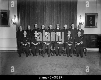 AMERICAN ADMIRALS PRESENTED WITH THE INSIGNIA OF THE MOST HONOURABLE ORDER OF THE BATH. 1 FEBRUARY 1944, THE FISH ROOM, ADMIRALTY HOUSE. THE FIRST LORD OF THE ADMIRALTY, MR A V ALEXANDER, PRESENTED REAR ADMIRAL ALAN G KIRK, USN, AND REAR ADMIRAL JOHN L HALL, USN, WITH THE INSIGNIA OF THE ORDER OF THE BATH. - Left to right: seated: Admiral H Stark, USN, Rear Admiral Alan G Kirk, USN, His Excellency the U S Ambassador, the Hon J G Winant, The Right Hon A V Alexander, Rear Admiral John L Hall, USN, and the First Sea Lord, Admiral of the Fleet, Sir Andrew B Cunningham. Standing are members of the Stock Photo