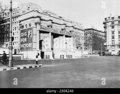 MINISTRY OF INFORMATION CAMPAIGN POSTERS, LONDON, UK, 1940 - A view of Marble Arch in London, which is used as a Ministry of Information 'special poster site'. On the side is a 'Dig for Victory' poster and across the front is a large banner encouraging the public to buy National War Bonds Stock Photo
