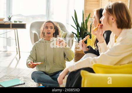 Diverse teenage girls gathered around a table, enjoying food and each others company in a heartwarming display of friendship. Stock Photo