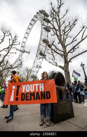 London, UK.  10 April 2024.  Members of a group called Youth Demand by the London Eye during a slow march around central London landmarks.  The group shows solidarity with Palestine and also demands an end to the issuing of fossil fuel licences by the British government.  Credit: Stephen Chung / Alamy Live News Stock Photo