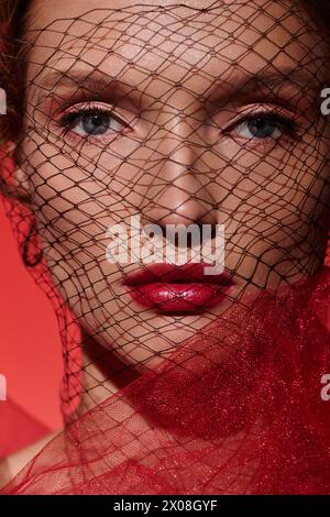 A young woman exudes classic beauty while posing with a veil covering her face in a studio setting. Stock Photo
