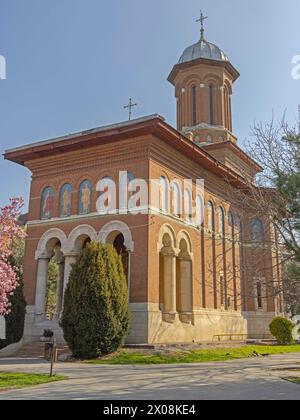 Craiova, Romania - March 16, 2024: Romanian Orthodox Holy Trinity Church at Prefecture Park in City Centre Spring Day. Stock Photo