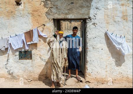 Two Moroccan men standing in front of a traditional home with a clothesline Stock Photo