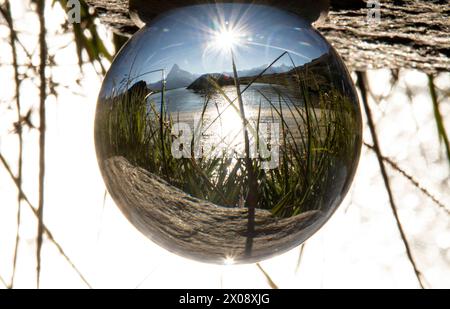 The Matterhorn mountain and surrounding landscape are beautifully captured within a crystal ball under the radiant sun, creating an enchanting inverte Stock Photo