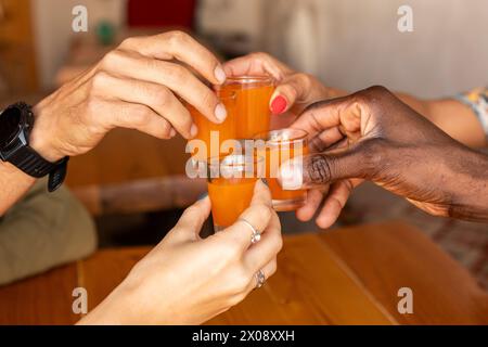 Group of diverse friends toasting with shots at a bar Stock Photo