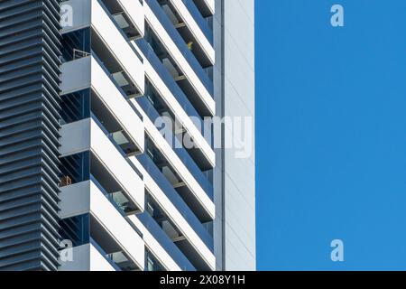 A crisp image showcasing the juxtaposition of a contemporary building's sharp angles against the clear blue sky Stock Photo