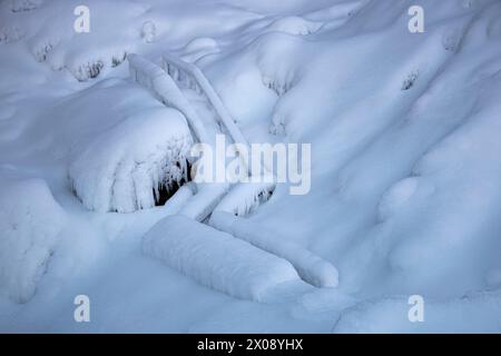 A serene Icelandic landscape covered in a thick layer of freshly fallen snow, with shapes and textures gently highlighted Stock Photo