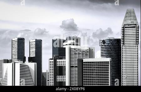 A monochromatic cityscape showing the impressive architecture of skyscrapers against a dramatic cloudy sky Stock Photo