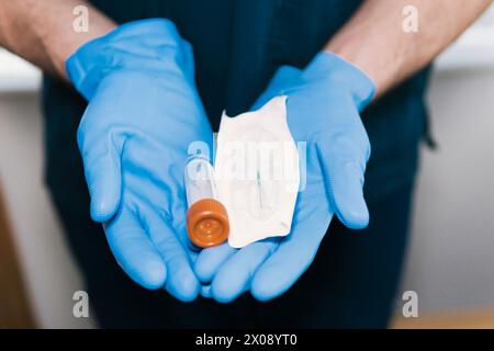 Close-up of anonymous gloved hands holding a sealed medical syringe and vial, ready for sterile medication administration Stock Photo