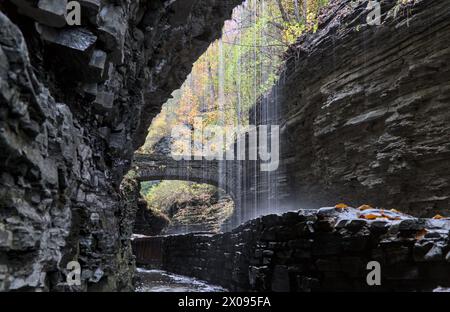 rainbow falls at watkins glen state park (waterfall in a gorge with stone bridge, staircase, glacial layered rock formation) falling water, stream, au Stock Photo