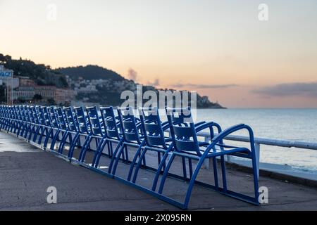 Blue chairs along the Promenade des Anglais, Nice France, at sunrise Stock Photo