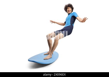 Young man in a wetsuit riding a surfboard isolated on white background Stock Photo