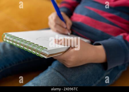 boy draws a sketch in a sketchbook. atmosphere of peace and tranquility. moment of creativity. a world full of colors, ideas and fantasies. Stock Photo