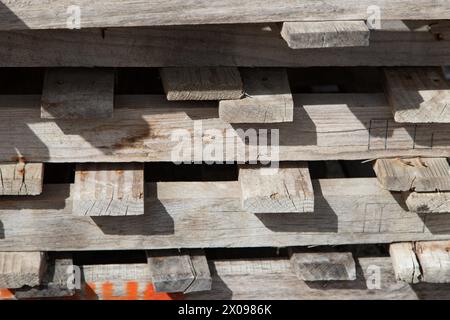 Background of old wooden pallets stacked on top of each other in outdoor environment. Wooden planks close up, texture Stock Photo