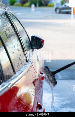 Side of a red car at a car wash Stock Photo