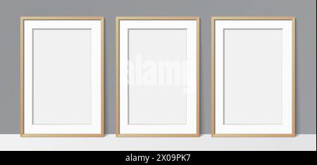 3 Blanck poster wooden frames leaning against a grey wall background. Poster gallery vector mockup for art, image, or text placement. Stock Vector