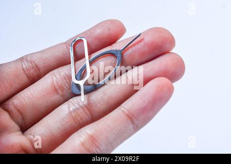 Close up of the "sim ejector" sim card opening tool inside a cell phone Stock Photo