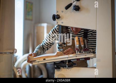 Carpenter man cuts out a chair top with an electric jig saw. Joiner working at sabre saw machine. Stock Photo