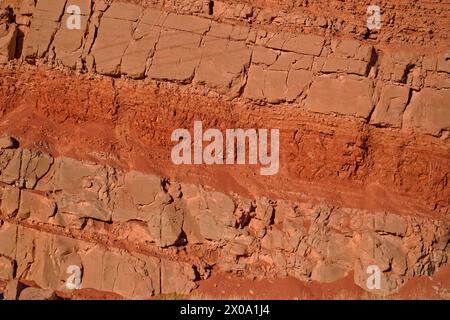 Red, iron-rich layered rock wall, texture detail close up. Stock Photo