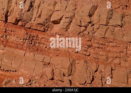 Red, iron-rich layered rock wall, texture detail close up. Stock Photo