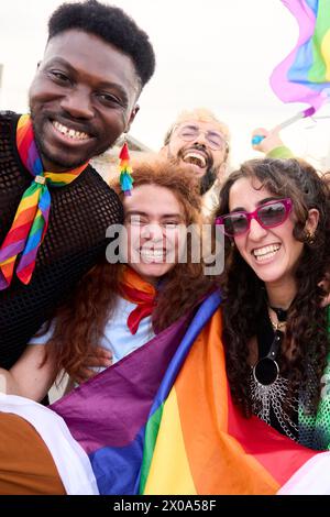 Happy group posing with rainbow flag for a fun event Stock Photo - Alamy