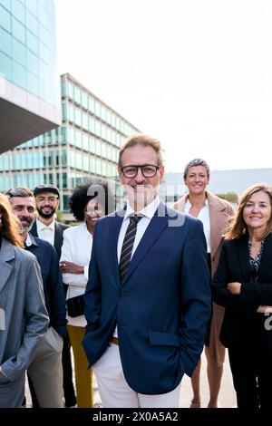 Cheerful smiling team of diverse business people in formal suit looking confident at camera Stock Photo