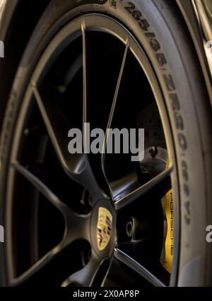 Detail image of a expensive black wheel and yellow disc brake cover on a porsche Stock Photo