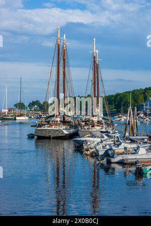 Tall ships and motorboats docked in Camden Harbor. Grace Bailey and Mercantile are two-masted schooners, serving as windjammer cruises from Camden, ME Stock Photo