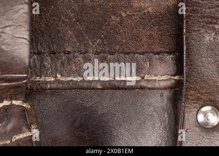 Leather product with rivets and seam. It occupies the entire surface of the image. Close-up. Stock Photo