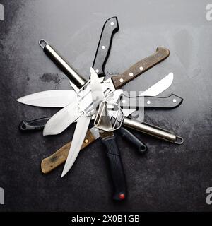 Kitchen, knives and tools with peeler on table in restaurant for cooking with professional set. Steel, service and metal slicer utensils on counter in Stock Photo