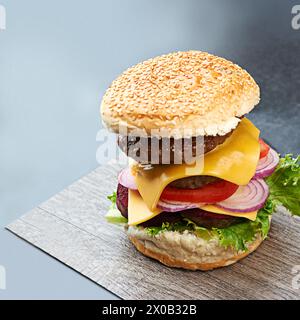 Beef, burger and cheese on menu in restaurant with lettuce, tomato and onion on sesame bun in kitchen. Bbq, hamburger and fast food with meat and Stock Photo