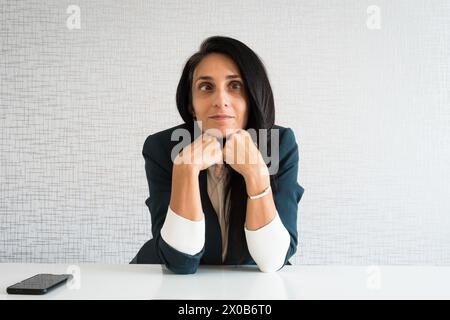 Young caucasian dumb business woman director in office. I don't know. Portrait dumb looking woman arms hold cheek with eye roll. Concept I don't know. Stock Photo