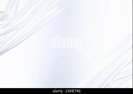 Luxury white satin background. Soft and elegant silk fabric. Flowing waves textile. Top view. Stock Photo
