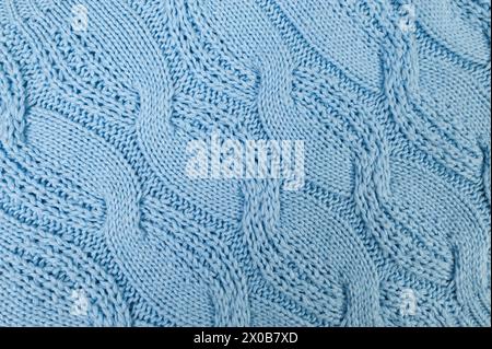 Blue knitted fabric background. Knitted braids texture. Stock Photo
