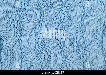 Blue knitted fabric background. Knitted braids texture. Stock Photo