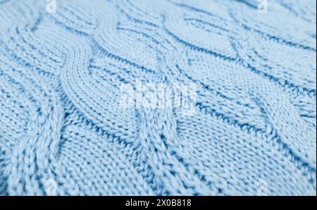 Blue knitted fabric background. Knitted braids texture. Stock Photo