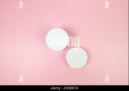 Top view of two white round podiums on pink background. Geometric abstract shapes for cosmetic product presentation. Flat lay, copy space. Stock Photo