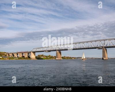 Sailboat sailing under Old Little Belt Bridge connecting Jutland and Funen in Southern Denmark, Denmark Stock Photo