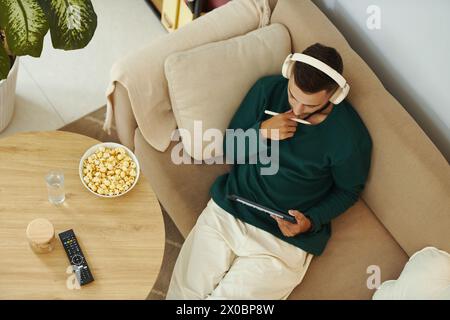 Creative young man sitting on couch with tablet and working on sketch Stock Photo